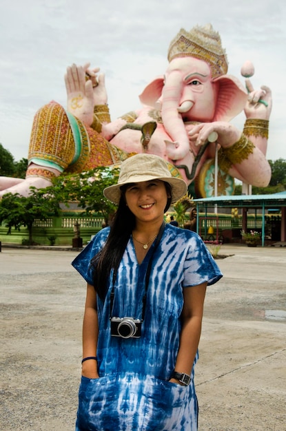 Una mujer tailandesa viaja y posa para tomar una foto con la estatua tailandesa de Big Ganesh llamada Phra Pikanet al aire libre para que la gente visite y respete la oración en el Parque Lord Ganesha en Nakhon Nayok Tailandia