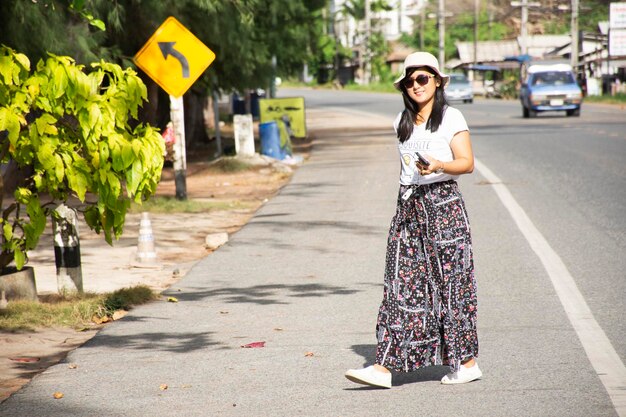 Mujer tailandesa de los viajeros que camina al lado del camino después de cruzar la calle de Ban Phe en la ciudad del pueblo de Banphe el 4 de julio de 2018 en Rayong Thailan