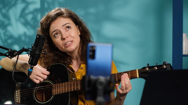 Foto una mujer talentosa tocando la guitarra durante una transmisión en vivo con la audiencia en línea
