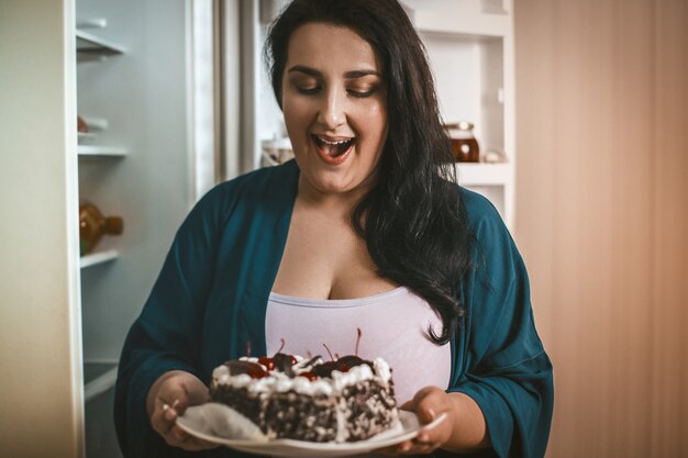 Mujer de talla grande admira mirando el postre de chocolate