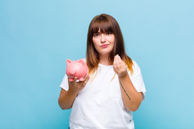 ¡Mujer de talla grande haciendo capice o gesto de dinero, diciéndote que pagues tus deudas!