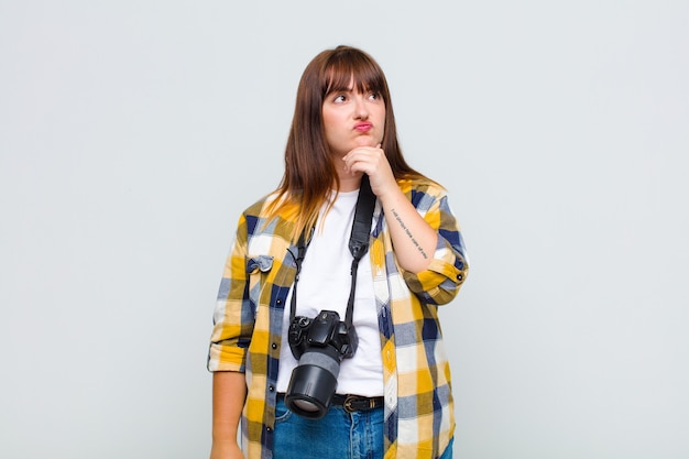 Mujer de talla grande pensando, sintiéndose dudosa y confundida, con diferentes opciones, preguntándose qué decisión tomar