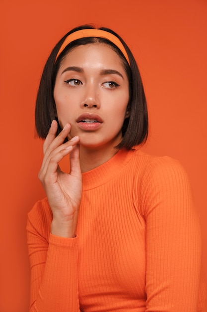 Foto mujer de talla media posando con traje naranja