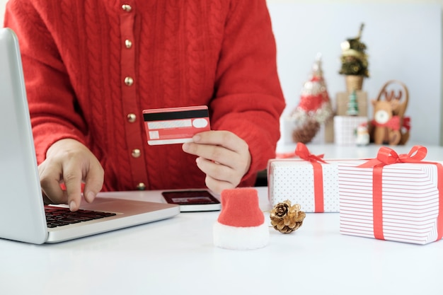 Mujer con tarjeta de crédito y haciendo compras en línea.