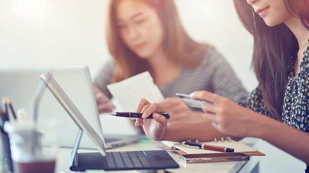 Mujer con tarjeta de crédito para pagar en compras online transfiriendo dinero a través de una tableta