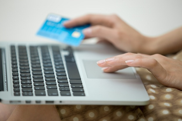 Foto mujer con una tarjeta de crédito y un portátil