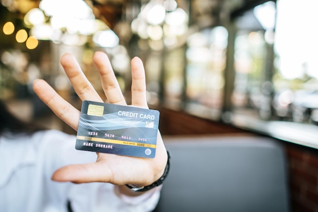 Foto mujer con tarjeta de crédito en un restaurante