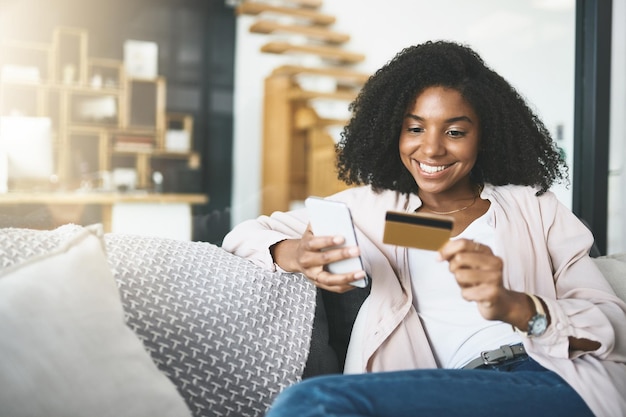 Mujer tarjeta y teléfono inteligente y relajarse en el sofá fintech y transacción para compras en línea en el hogar Cliente pago en Internet y aplicación de venta o banca comercio electrónico y sonrisa o compra en apartamento