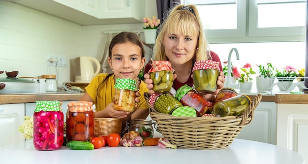 Mujer con tarro de verduras en conserva para el invierno madre e hija Enfoque selectivo