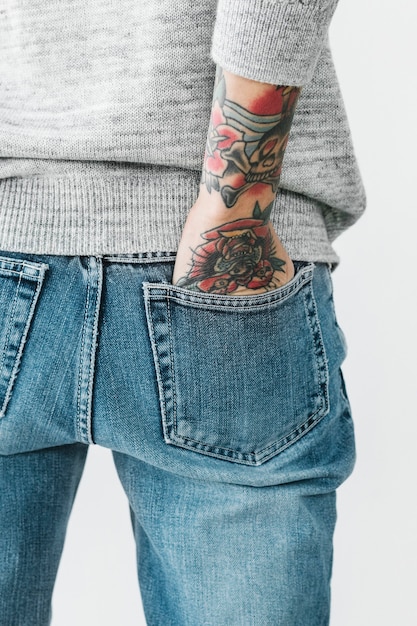 Mujer tatuada con la mano en el bolsillo de los pantalones vaqueros