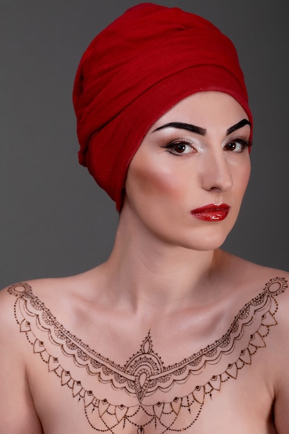 Mujer con tatuaje de henna y turbante rojo