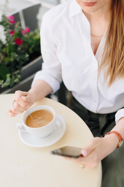 Foto una mujer con una taza de café en un café al aire libre de verano