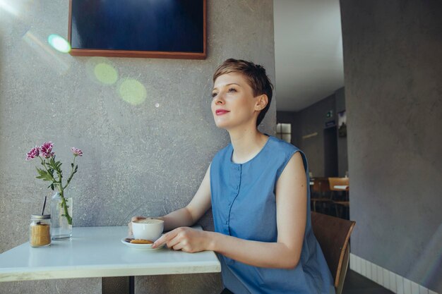 Mujer con una taza de café en una cafetería