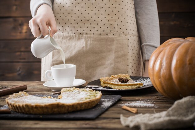 Mujer con taza de café y pastel de calabaza