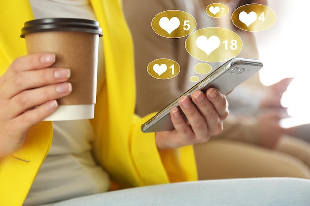 Foto mujer con taza de café con smartphone closeup