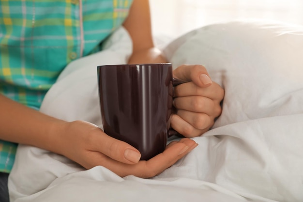 mujer, con, taza, en cama, en casa, primer plano