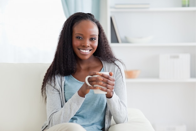 Mujer con taza en el sofá