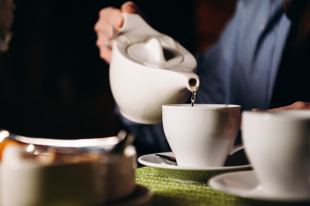 Una mujer con una taza de té caliente en sus manos se sienta en el restaurante La niña bebe té aromático Disfruta el momento tómate un descanso