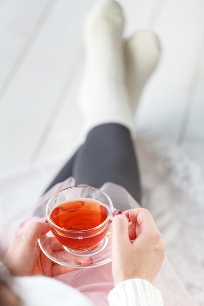 Mujer con taza de té Plaid de descanso, pie con calcetines blancos