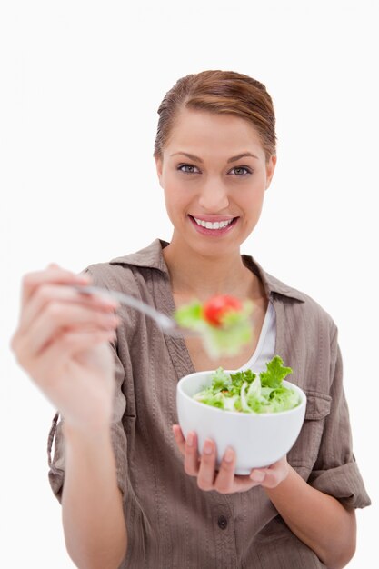 Foto mujer con tazón de ensalada ofreciendo algunos