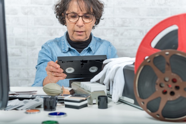 Mujer técnica con casete VHS para digitalización