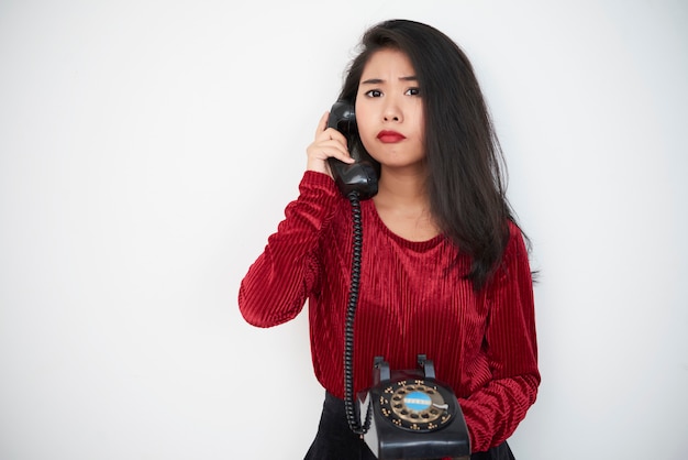 Mujer con teléfono antiguo