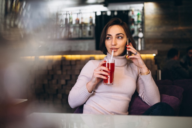 Mujer con teléfono en una cafetería