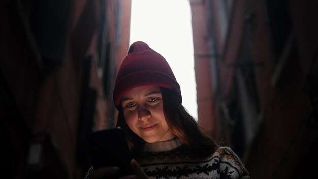 La mujer en el teléfono del callejón estrecho resalta su rostro