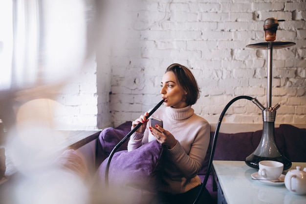 Mujer con teléfono fumar shisha