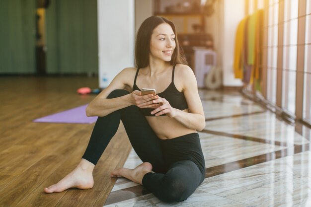 Mujer con teléfono en el gimnasio