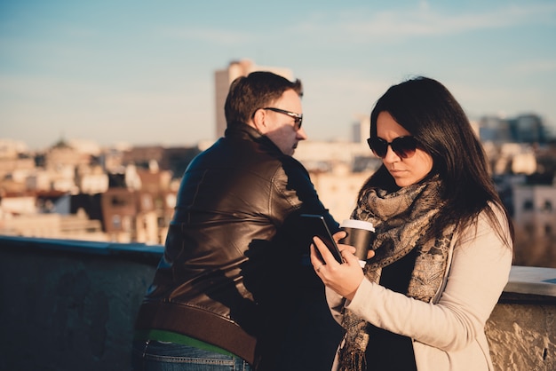 Mujer con teléfono inteligente en la azotea