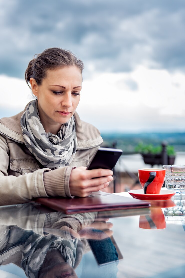 Foto mujer con teléfono inteligente en el café