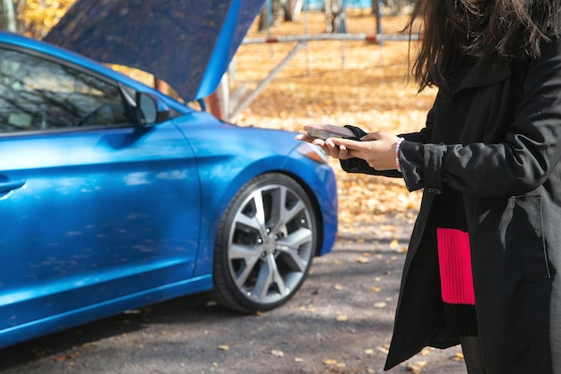 Mujer con teléfono inteligente llamando al servicio de automóviles