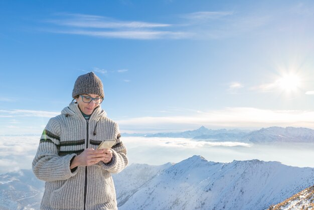 Mujer con teléfono inteligente en las montañas.