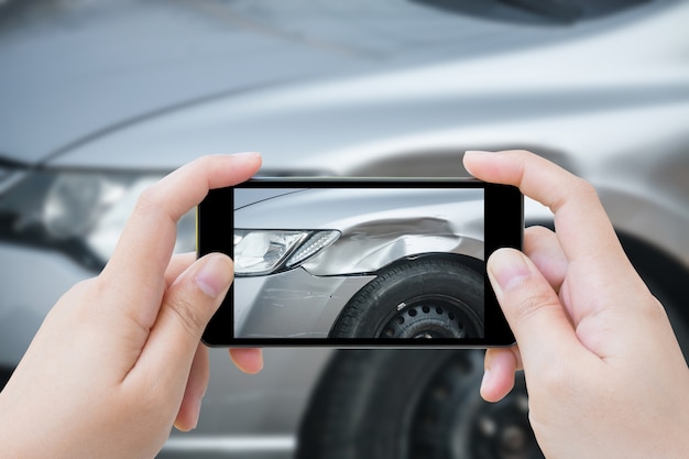 Mujer con teléfono inteligente móvil tomar foto accidente de coche