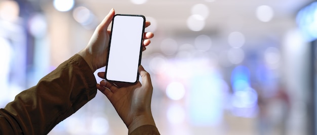 Una mujer con teléfono inteligente de pantalla en blanco