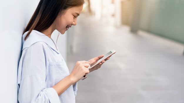 Mujer con teléfono inteligente, durante el tiempo libre.