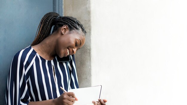 Mujer en el teléfono mientras toma notas