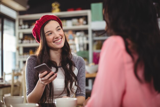 Foto mujer con teléfono móvil en café