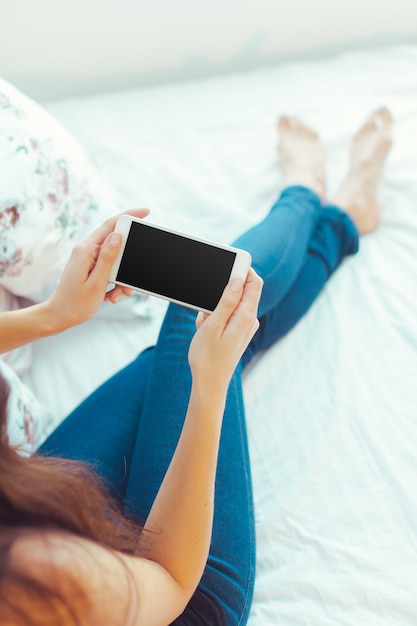 Mujer con teléfono móvil moderno en manos