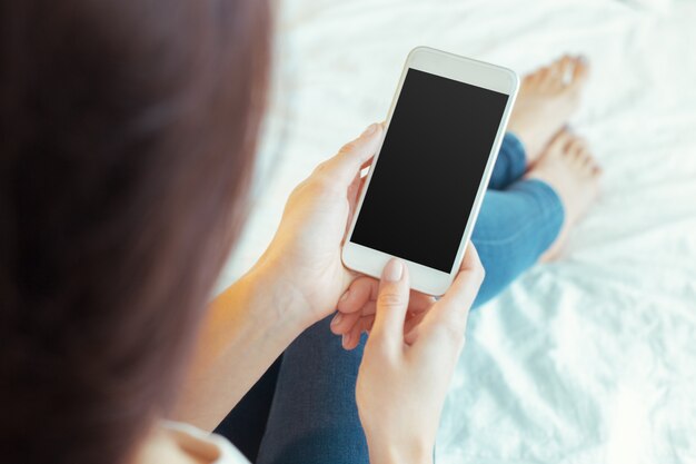 Mujer con teléfono móvil moderno en manos