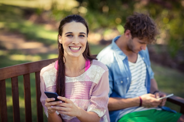 Mujer con teléfono móvil en el parque