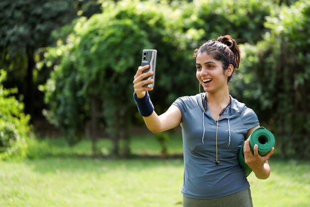 una mujer con un teléfono y una pelota en la mano