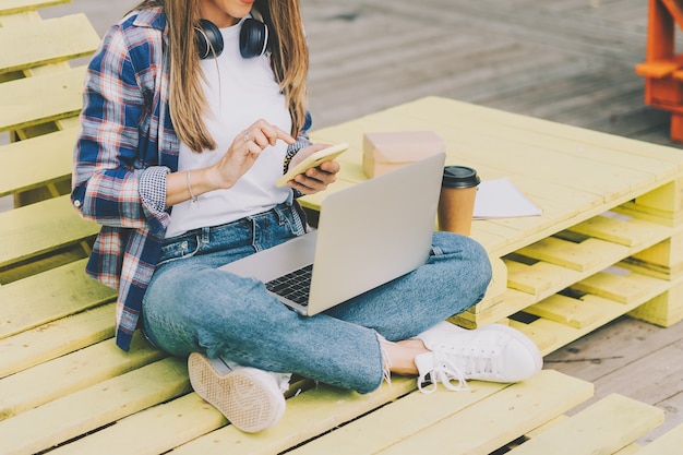 Mujer con teléfono portátil y auriculares