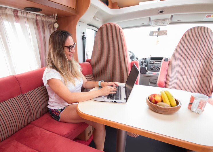 Foto mujer teletrabajando en una autocaravana o autocaravana como oficina