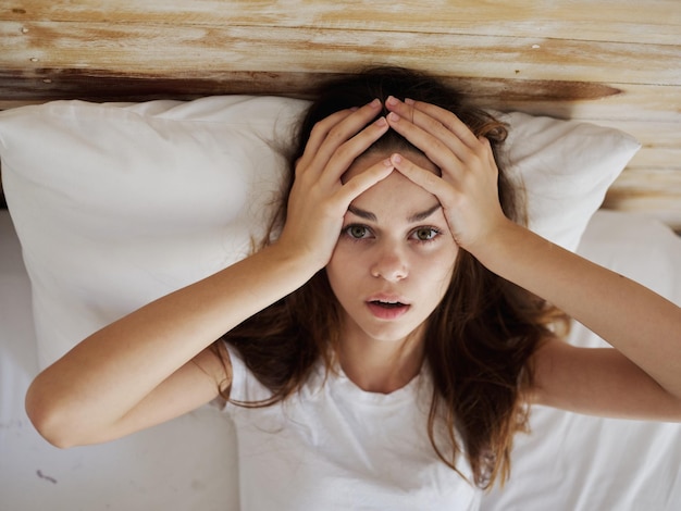 Mujer con la temperatura de la cabeza acostada en la cama foto de alta calidad