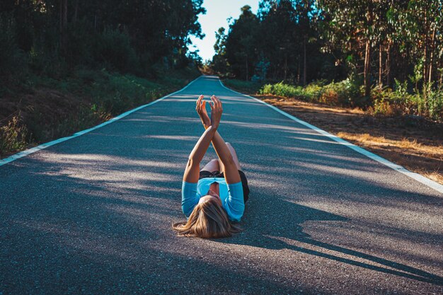 Foto mujer tendida en la carretera