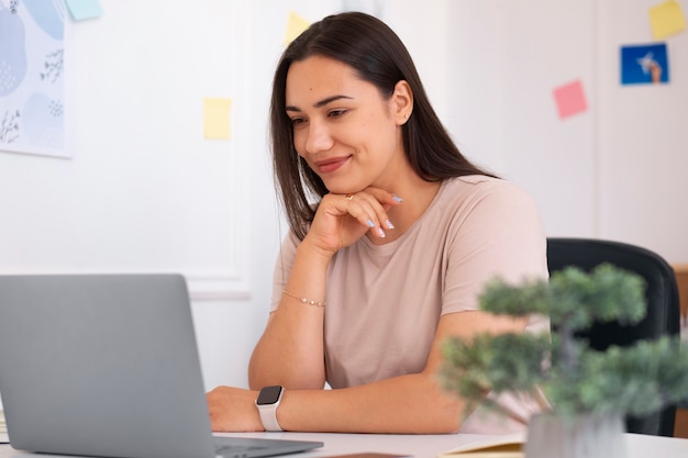 Mujer teniendo una videollamada usando un dispositivo portátil desde casa