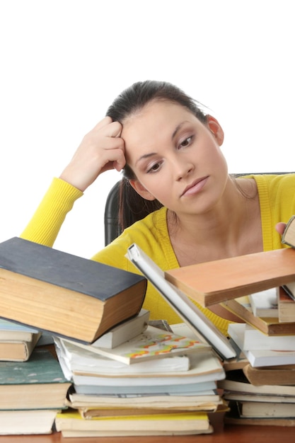 Foto mujer tensa mirando libros contra un fondo blanco