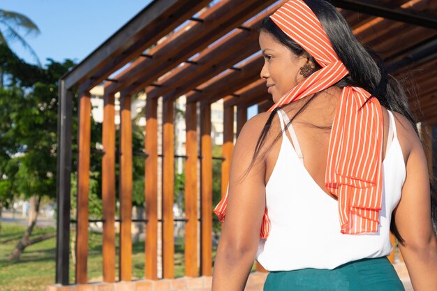 Mujer con una tiara roja caminando por el parque